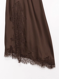 Detailed view of the dark brown satin dress hem featuring delicate eyelash lace trim