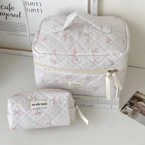 Close-up of quilted cotton cosmetic bags with pink polka dots and bow detailing