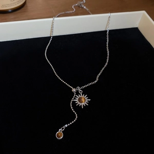 Détail du pendentif tournesol avec pierre œil de tigre sur collier argenté en Y