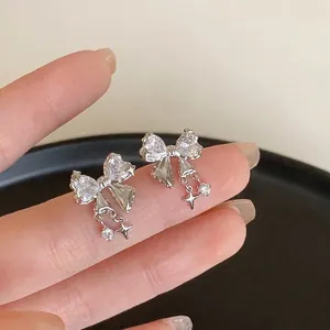 Détail de boucles d'oreilles nœud en argent avec zircons et pendentifs étoiles