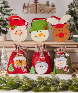 Detail view of felt Christmas gift bags featuring Santa, snowman, and reindeer designs