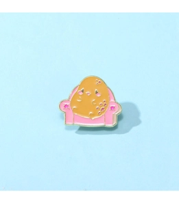 Détail d'un pin's en émail représentant une pomme de terre sur un fauteuil rose