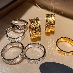 Detailed macro view of 18k gold and silver pleated rings with hammered relief texture