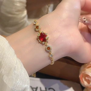 Detail view of 18k gold plated bracelet featuring oval red and orange zircon stones