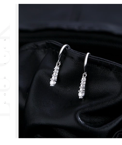 Macro detail of elegant 925 silver dangling earrings with five cascading moissanite stones