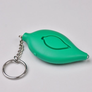 Macro detail of leaf-shaped personal safety alarm in green with metal keychain