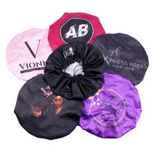 Flat lay of multiple colorful satin sleep bonnets with wide elastic bands for hair protection