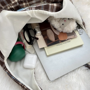 Detail showing spacious interior of the plaid tote bag fitting a laptop and daily essentials
