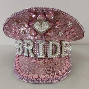 Detailed view of pink sequin captain hat featuring large pearl Bride lettering and heart gems