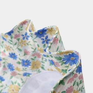 Détail d'un chapeau de soleil d'été avec imprimé floral coloré et texture de tissu ondulé