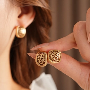 Détail de boucles d'oreilles vintage avec imprimé léopard et finition dorée sur le mannequin