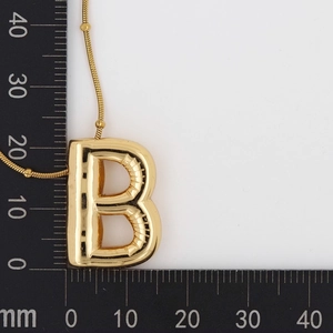 Detailed measurement of gold balloon letter B pendant with snake chain on a black scale