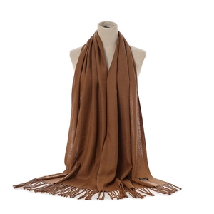 Close-up of camel cashmere-style scarf showing soft twill texture and tassel fringe detail