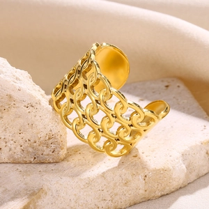 Macro view of gold-plated stainless steel hollow intertwined ring on a natural stone base