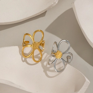 Modische hohle Blumenringe in Gold und Silber auf einem künstlerischen Steinsockel