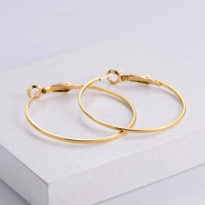 Textured 18k gold plated round hoop earrings with embossed grid pattern on white stand