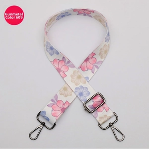 Detail of adjustable floral canvas strap with dark gunmetal grey swivel hooks and slide buckle