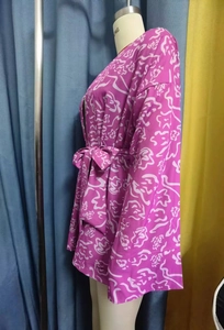 Vue latérale du peignoir kimono en satin rose avec motifs abstraits blancs sur mannequin