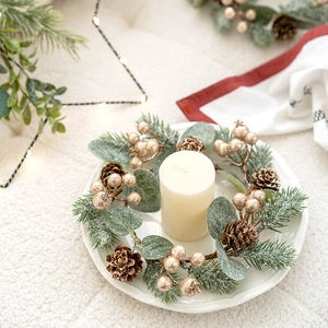 Weihnachtskranz-Kerzenhalter mit roten Zapfen und weißer Kerze auf Keramiktablett