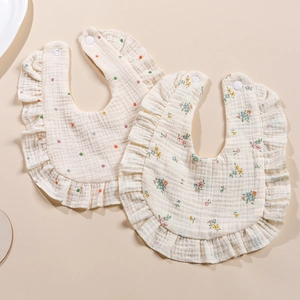 Detail of soft four-layer cotton muslin bibs with ruffle edges and snap buttons