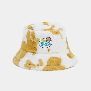 Plush fuzzy bucket hat in yellow and white cow print with Sea Breeze embroidery patch