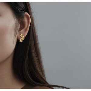 Elegant gold S925 sterling silver floral stud earrings on model for a natural look