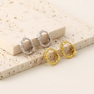 Detail of s925 silver and gold twisted earrings with star charms and crystals