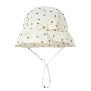 Detail of baby cotton sun hat with brown polka dots, wavy brim, and adjustable strap