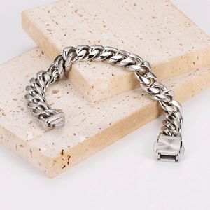 Polished silver cuban link bracelet for men on natural travertine stone base