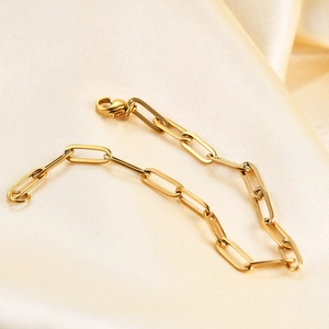 Minimalist 14K gold plated paperclip link chain bracelet on elegant satin background