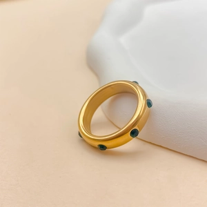Détail macro d'une bague en acier inoxydable plaqué or 18K avec cristaux verts