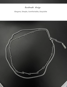 Close-up of double-layer stainless steel wheat chain with lobster clasp and logo tag