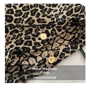Detail of golden magnetic snap closure on leopard print canvas tote bag