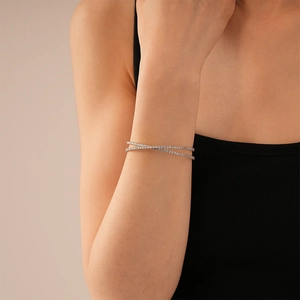 Détail du bracelet géométrique croisé en argent avec zircons sertis sur le poignet