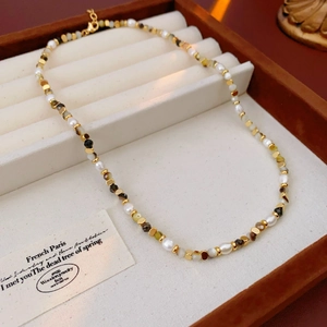 Detailed close-up of mixed freshwater pearls and vintage stone beads in a wooden jewelry box