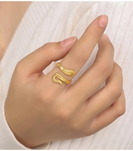 Detailed close-up of a gold-plated snake ring with textured scales and adjustable band
