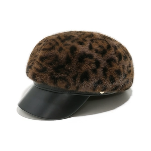 Detail of leopard print faux fur newsboy cap with black leather brim and gold metal button