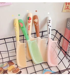 Close-up of cute cartoon hair combs with 3D animal and fruit reliefs in a storage basket