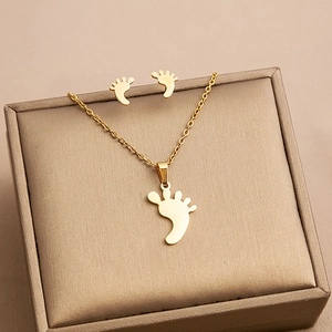 Detailed view of golden stainless steel jewelry set featuring baby footprint pendants