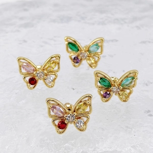 Macro shot of colorful zircon butterfly earrings on ice textured background