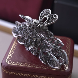 Macro shot of retro metal hair claw with rhinestones on a red jewelry box