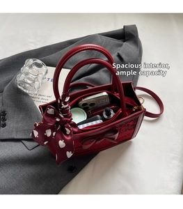 Detailed view of spacious interior in red faux leather bag with bow and silk scarf accents