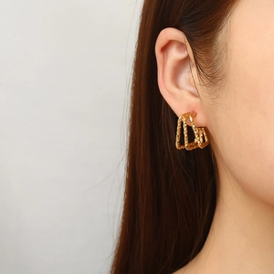 Textured multi-layer square 18K gold stainless steel earrings worn by a model