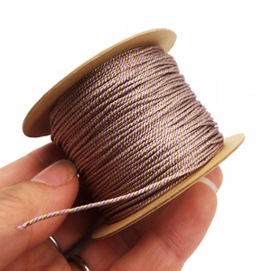 Detail of 1mm pink and gold twisted cord roll for DIY jewelry making and tassels