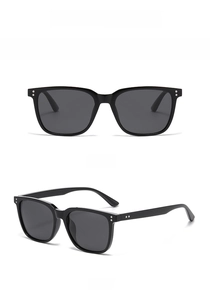 Close-up of black square frame sunglasses with silver rivets and grey polarized lenses