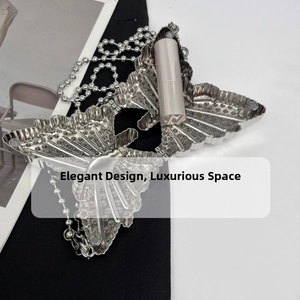 Detailed macro view of silver butterfly rhinestone lipstick holder with bead chain