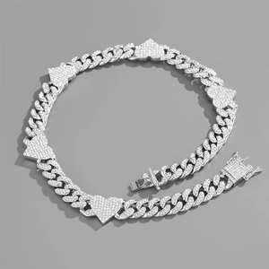 Close-up of silver Cuban link necklace featuring five sparkling heart pendants with rhinestones