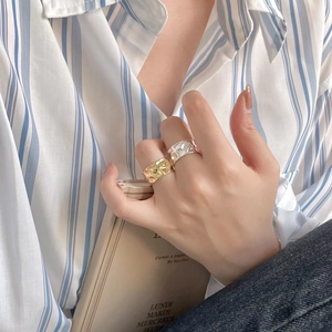 Close-up of hammered gold and silver 925 sterling silver rings worn on hand