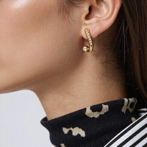 Snake shaped gold stainless steel earrings with sparkling diamonds on female model