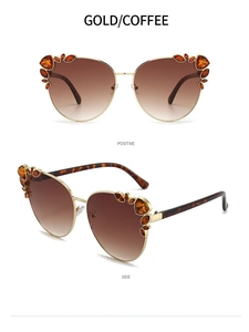 Detail of gold cat eye sunglasses with coffee lenses and amber rhinestone accents
